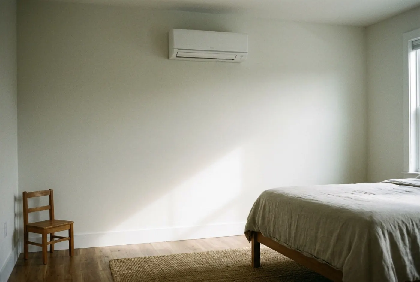 A ductless mini-split head newly mounted on a bedroom wall
